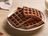 Gaufres au chocolat fraîches, servies sur une assiette avec un verre de lait.