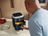 Andre Agassi using a SILVERCREST air fryer to cook crispy potato cubes in a modern kitchen.