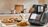 Monsieur Cuisine smart kitchen appliance on a countertop, displaying a recipe on its touchscreen with prepared food beside it.