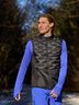 Expert Tim in een zwart CRIVIT-functioneel herenvest en een blauw functioneel shirt met een blauwe functionele korte broek op een bospad.