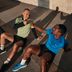 Zwei Männer in CRIVIT-Sportbekleidung geben sich nach dem Training draußen einen Faustgruß