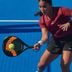 Frau in CRIVIT-Sportbekleidung im Einsatz beim Padel auf einem blauen Platz