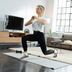 CRIVIT‑Fitnessexpertin Linda macht einen Ausfallschritt auf einer Trainingsmatte im hellen Wohnzimmer.