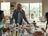 Andre Agassi stands at a lavishly laid table where a woman and a man are seated.