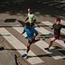 Twee mannen en een vrouw in CRIVIT-hardloopkleding joggen over een zebrapad