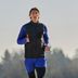 Hardloopexpert Tim gaat hardlopen in de vrije natuur, gekleed in zwarte en blauwe hardloopkleding van CRIVIT.