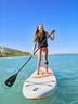 Una mujer en el agua sobre una tabla de SUP de CRIVIT