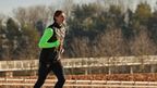 Expert Tim jogt buiten in zwarte en neongroene CRIVIT-hardloopkleding.