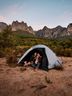 Happy couple sitting in a tent in the mountains