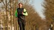 Volledige lichaamsfoto van expert Tim in zwarte en neon groene hardloopkleding tijdens het hardlopen in de buitenlucht.