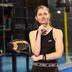 Une joueuse de padel pensive, vêtue d'une tenue CRIVIT noir et blanc, tient une raquette de padel CRIVIT et se tient sur le terrain.