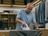 Andre Agassi is ironing a shirt. An open wardrobe can be seen in the background.