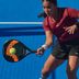 Woman in CRIVIT sportswear playing padel on a blue court