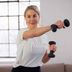 CRIVIT-fitnessexpert Linda demonstreert een thuisworkoutoefening met twee halters.