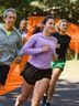 A group of people jogs together in a park, enjoying a sunny day and staying active