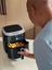 Andre Agassi utiliza una freidora de aire SILVERCREST para cocinar dados de patata crujientes en una cocina moderna.