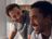 Two men smiling and enjoying a lighthearted moment together in a bright, modern kitchen.