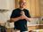 Andre Agassi lächelt, während er in seiner Küche eine Mahlzeit serviert, die mit dem Kupfer-Kochgeschirr der Signature Edition zubereitet wurde.