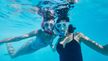 Dos mujeres haciendo snorkel bajo el agua con máscaras y tubos CRIVIT