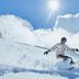 Man in CRIVIT snowboard jacket carving down a snowy slope