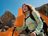 Stefanie Graf hiking in the mountains wearing CRIVIT outdoor wear, with an orange CRIVIT logo in the background.
