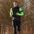 Expert Tim rent buiten in zwarte en neongroene CRIVIT-hardloopkleding.