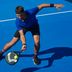 Un homme vêtu d'une tenue de sport CRIVIT jouant au padel sur un terrain bleu