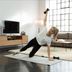 Fitness expert Linda performs a side‑support exercise with a CRIVIT dumbbell in a bright living room.