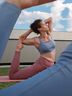 Group stretching outdoors on pink mats wearing CRIVIT activewear