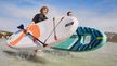 Two people in CRIVIT wetsuits carrying SUP boards into the sea