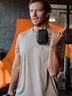 A man lifts a dumbbell in a gym, focusing on strength training.